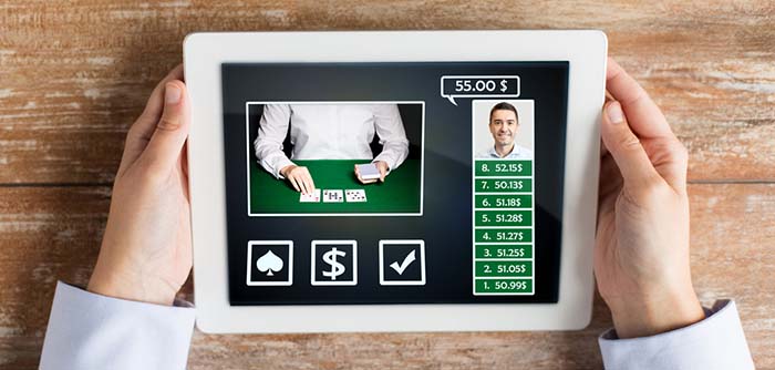 kasino, online kockanje, tehnologija i ljudi - krupni plan igrača pokera s tablet računalom za stolom