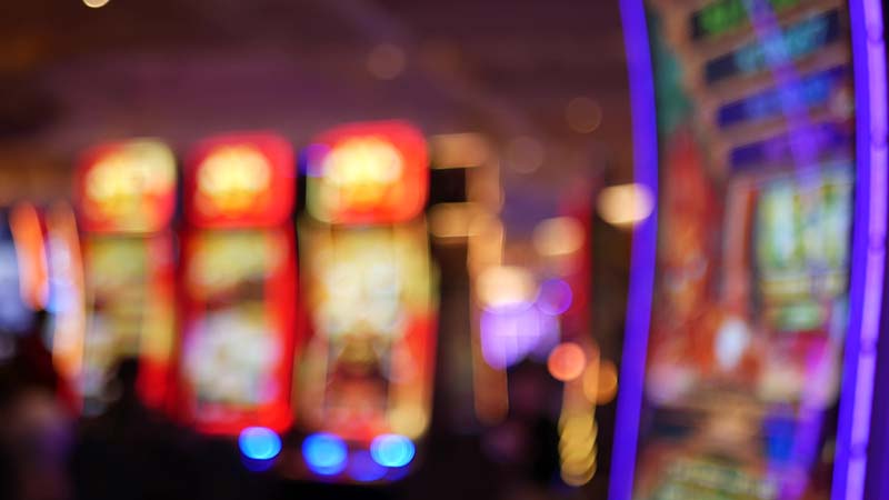 Defokusirani automati za igre na sreću svijetle u kasinu na prekrasnom Las Vegas Stripu, SAD. Zamućeni automati za jackpot za kockanje