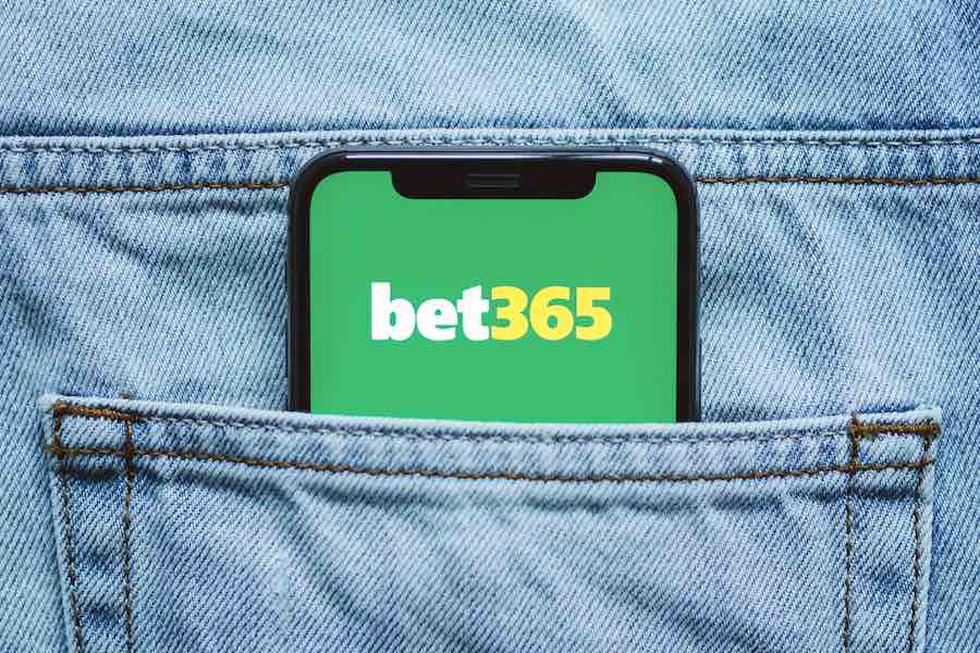 Logo aplikacije za klađenje Bet365 na ekranu mobilnog telefona u džepu traperica. Bet365 je sportska kladionica registrirana na Malti.